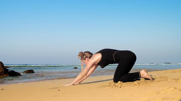 Barefoot Girl in Black Tracksuit Exercises on Sandy Beach