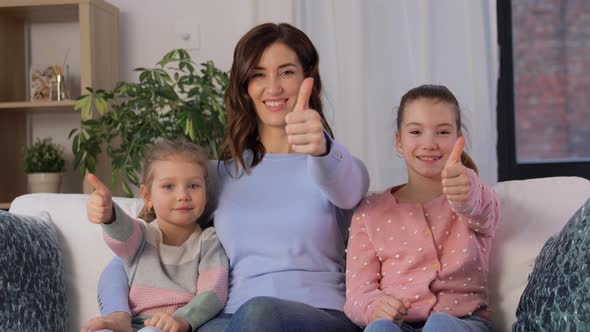 Mother and Daughters Showing Thumbs Up at Home