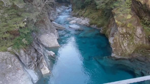 Beautiful view from a suspension bridge on crystal clear water in a river in New Zealands.