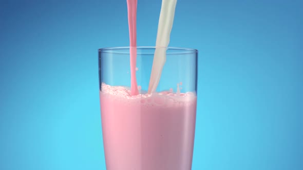 Milk and strawberry milk pouring into glass, Slow Motion