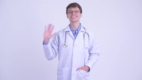 Happy Young Handsome Man Doctor Waving Hand