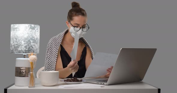 Sick Woman in Medical Mask Works at Home, She Seats at the Table and Reading Paper Documents and