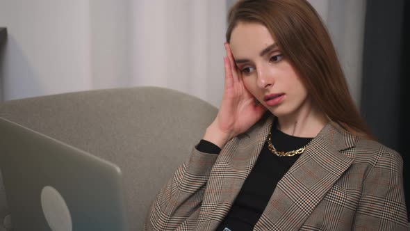 Portrait of Upset Woman Using Laptop Watching Content Browsing Internet Has a Headache Sitting on