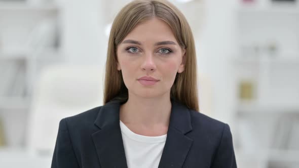 Portrait of Serious Young Businesswoman Looking at Camera