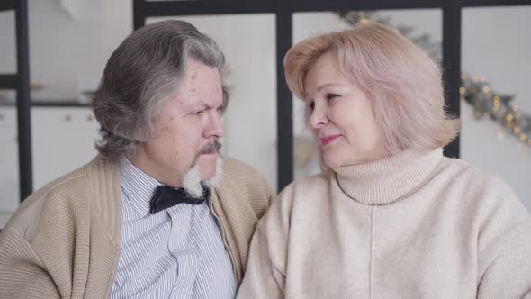 Close-up Portrait of Happy Senior Couple Talking on Christmas Eve. Smiling Handsome Mature Man and