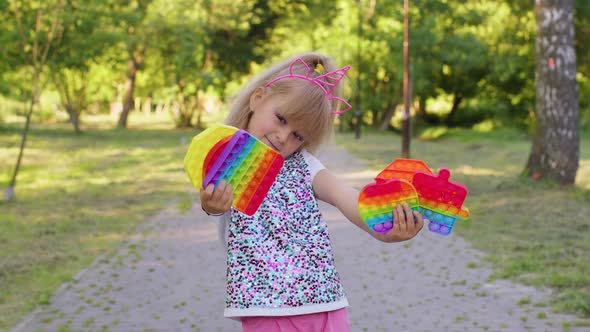 Smiling Child Girl Kid Holding Squeezing Antistress Pop It Touch Screen Toys Simple Dimple Game