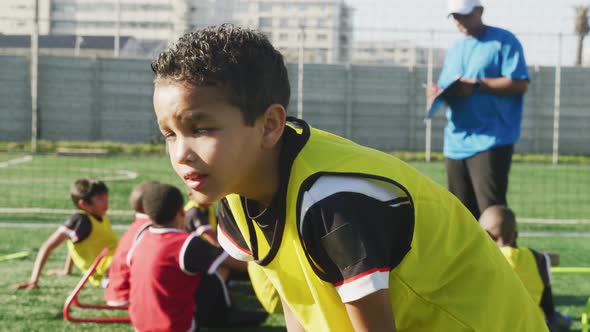 Mixed race soccer kid exercising in a sunny day