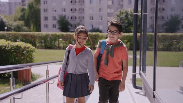 Children Walking to School Teacher Measures Their Temperature with Thermometer