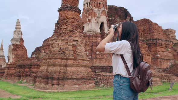 Asian woman using camera for take a picture while spending holiday trip at Ayutthaya,