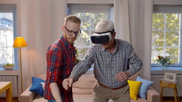 Adult Son and Retired Father Playing Games in Vr Headset Together at Home