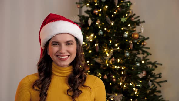Portrait Smiling Woman in Santa Claus Hat Looks Camera at Home Christmas Tree