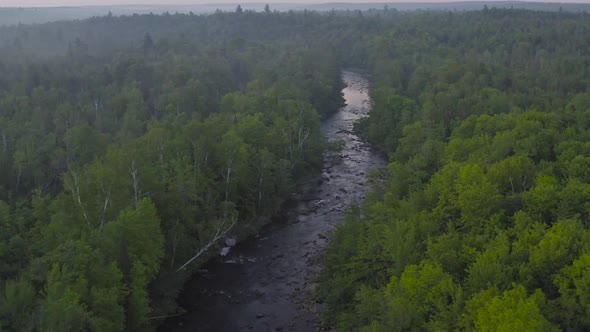 Wide landscape aerial shot of river cutting through wilderness