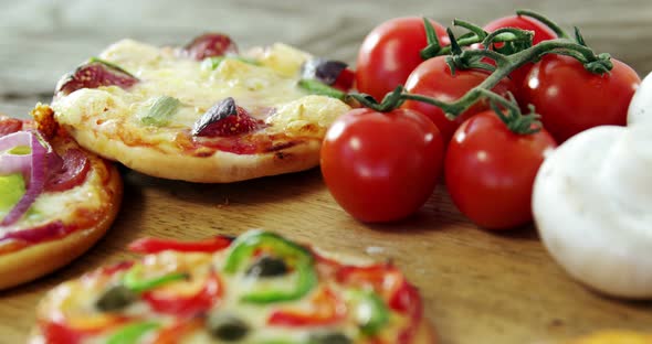 Italian pizza on wooden table with vegetables and spices