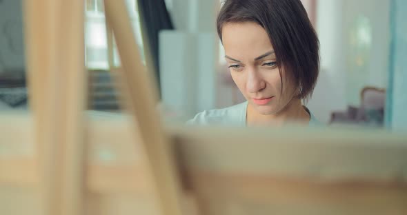 Young Cute Girl Draws at the Easel