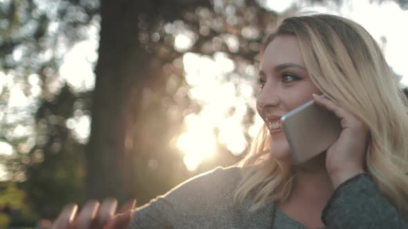 Happy Young Woman Talk On Mobile Phone Outdoors