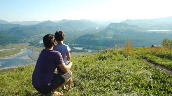 Portrait Of Father With His Son Looking To The Mountains