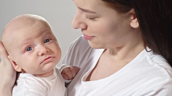 Yawning Baby on Mother’s Arms