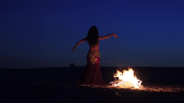 Late Night a Girl in the Sand Dancing Belly Dancing Near a Bright Campfire