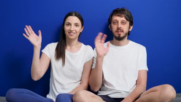 Man with a Beard and a Woman in White T-shirts Are Sitting