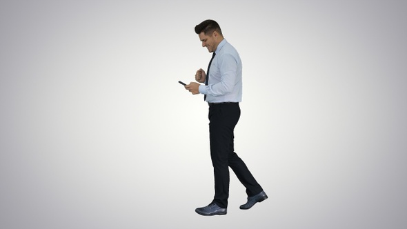 Man Walking Looking on Phone and Making Win Gesture On