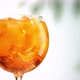 glass of aperol spritz cocktail with ice turning on defocused leaves background zoom in - VideoHive Item for Sale