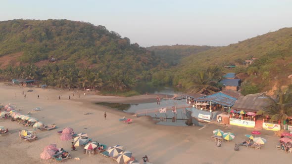 Beach Shacks and small sweat water lake in Arambol, North Goa, India - Aerial Low angle Orbit shot