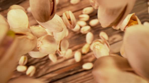 Super Slow Motion Shot of Fresh Roasted Pistachio Nuts Falling on Wooden Table at 1000 Fps