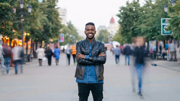 Zoom Out Time-lapse of Emotional African American Man Standing in Street with Arms Crossed and