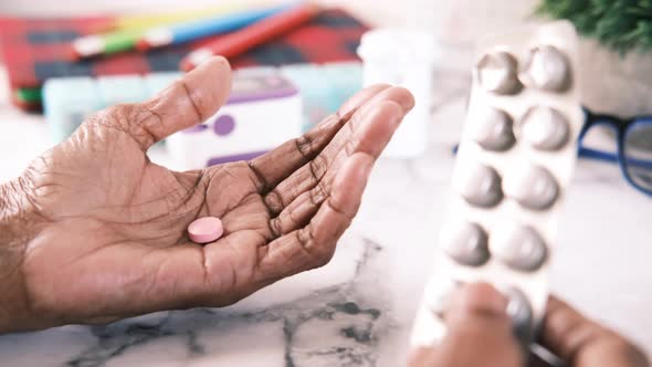 Senior Hand Holding Single Medical Pills and a Blister Pack