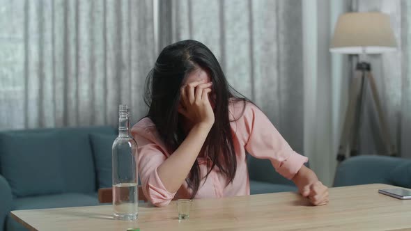 Drunk, Depressed Asian Woman Drinking Vodka Before Using A Fist Smashing The Table At Home