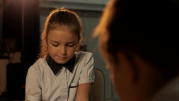 Intelligent girl playing chess with a young boy