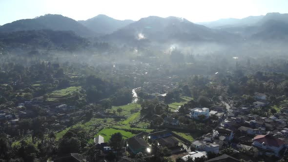 Cinematic aerial view of foggy valley with mountains in the morning