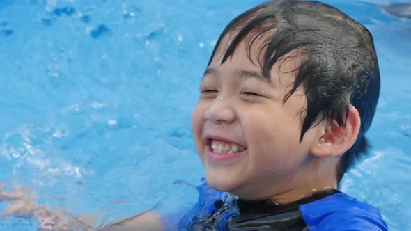 Cute Asian Boy Swimming And Playing In A Pool Slow Motion