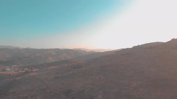 Drone flying towards mountain with mountains i background.