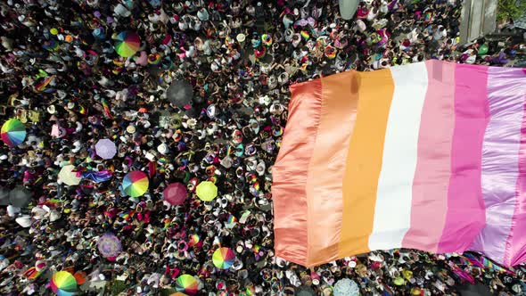 aerial drone shot of many people waving the pride flag in pride parade in mexico city