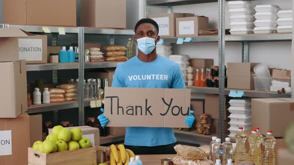 Man in Mask and Gloves Holding Thank you Banner at Bank