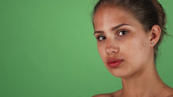 Studio Shot of a Beautiful Young Woman with Flawless Skin Looking To the Camera