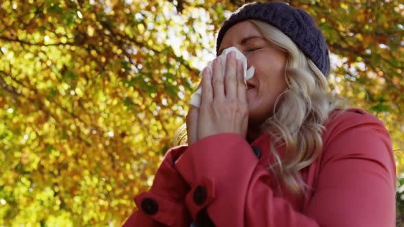 Woman is blowing her nose