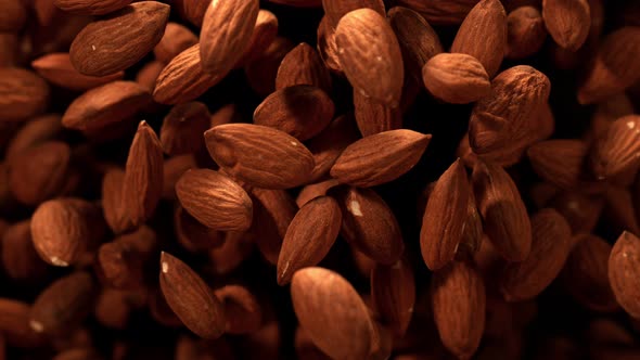 Super Slow Motion Shot of Almonds Flies After Being Exploded Against Black Background 1000Fps