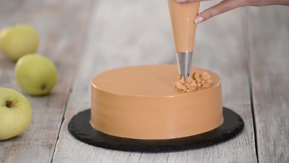 Chef Decorating Cake with Caramel Cream.