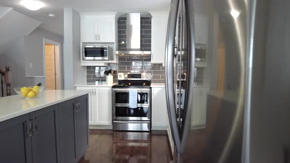 real estate high end kitchen reveal from behind stainless fridge smooth gimbal