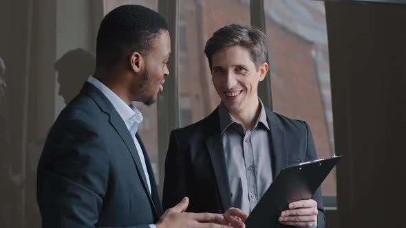 Caucasian Businessman Manager Showing Document to Afro American Man Colleague Boss Employer