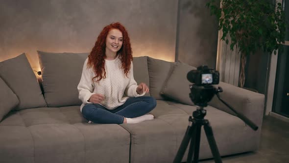 Attractive Curly Red Headed Young Girl Vlogger is Talking in Front of Camera Recording Video for