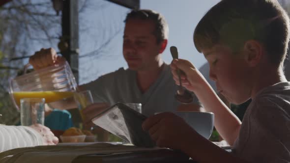 Family eating breakfast together outdoors