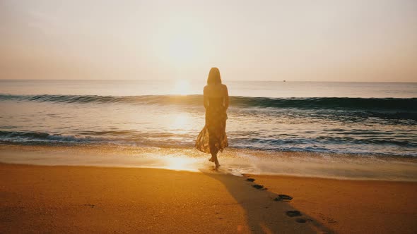 Back View Backlight Shot of Happy Young Woman Watching Epic Sunset on Golden Tropical Ocean Beach