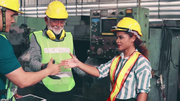 Group of Factory Workers Using Machine Equipment in Factory Workshop