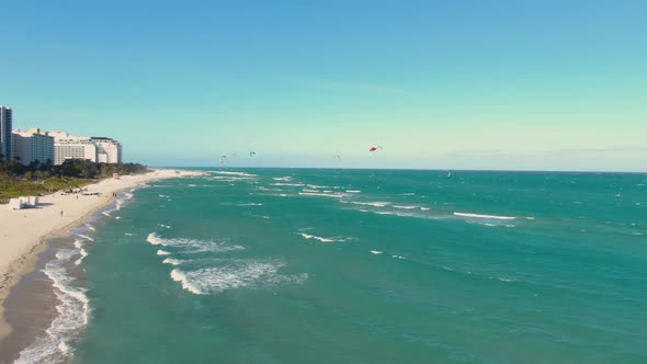 Tourists Parasailing On The Midbeach Section Of Miami Beach, Florida, United States. aerial, left sl