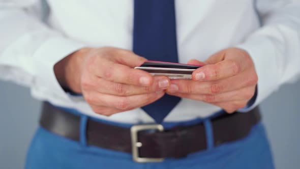 Formally Dressed Man Selects a Credit Card From Several