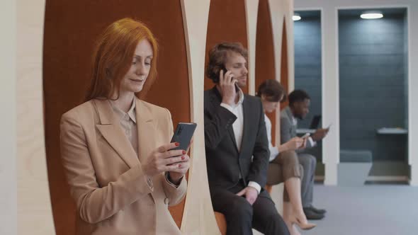 Portrait of Red-haired Caucasian Businesswoman Using Mobile Phone