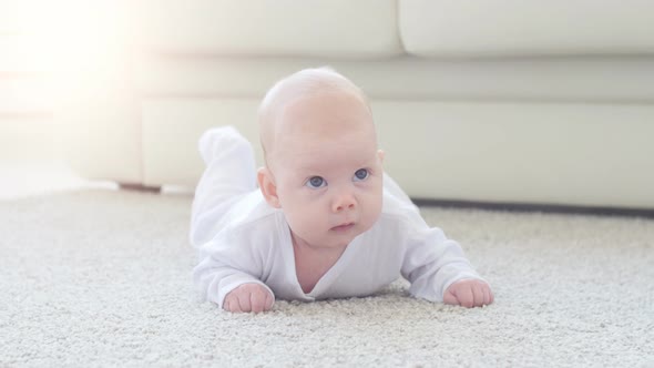 Cute Funny Baby Lying on a Beige Carpet